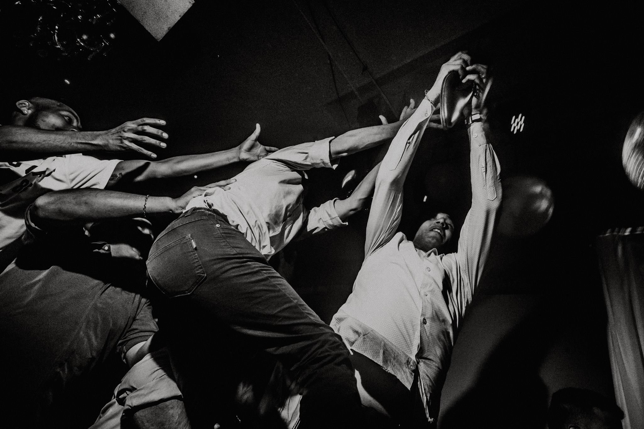 Black and white photo of energetic crowd surfing at a lively concert event. Fotógrafo de Bodas en Formosa