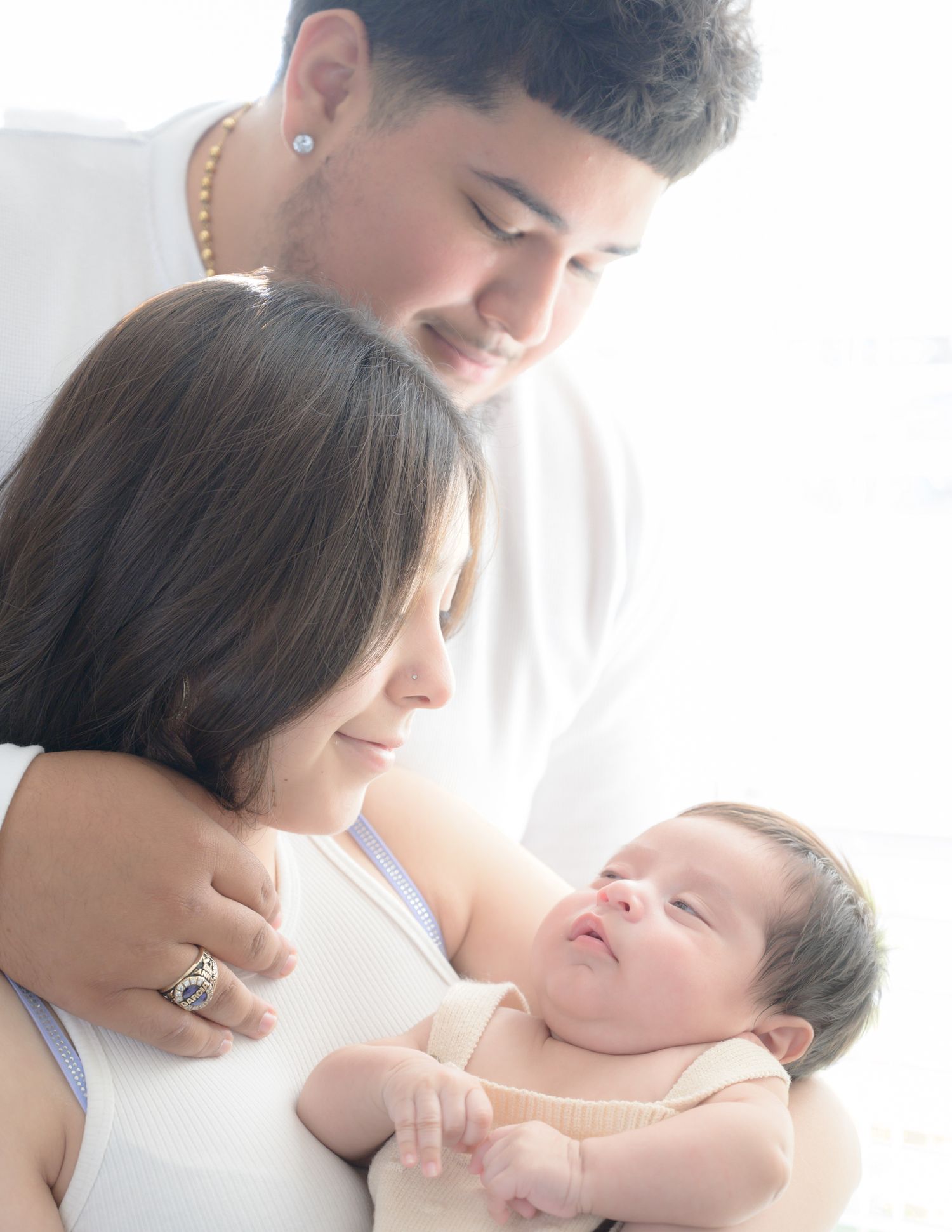 Tender family moment with newborn baby nestled between parents.