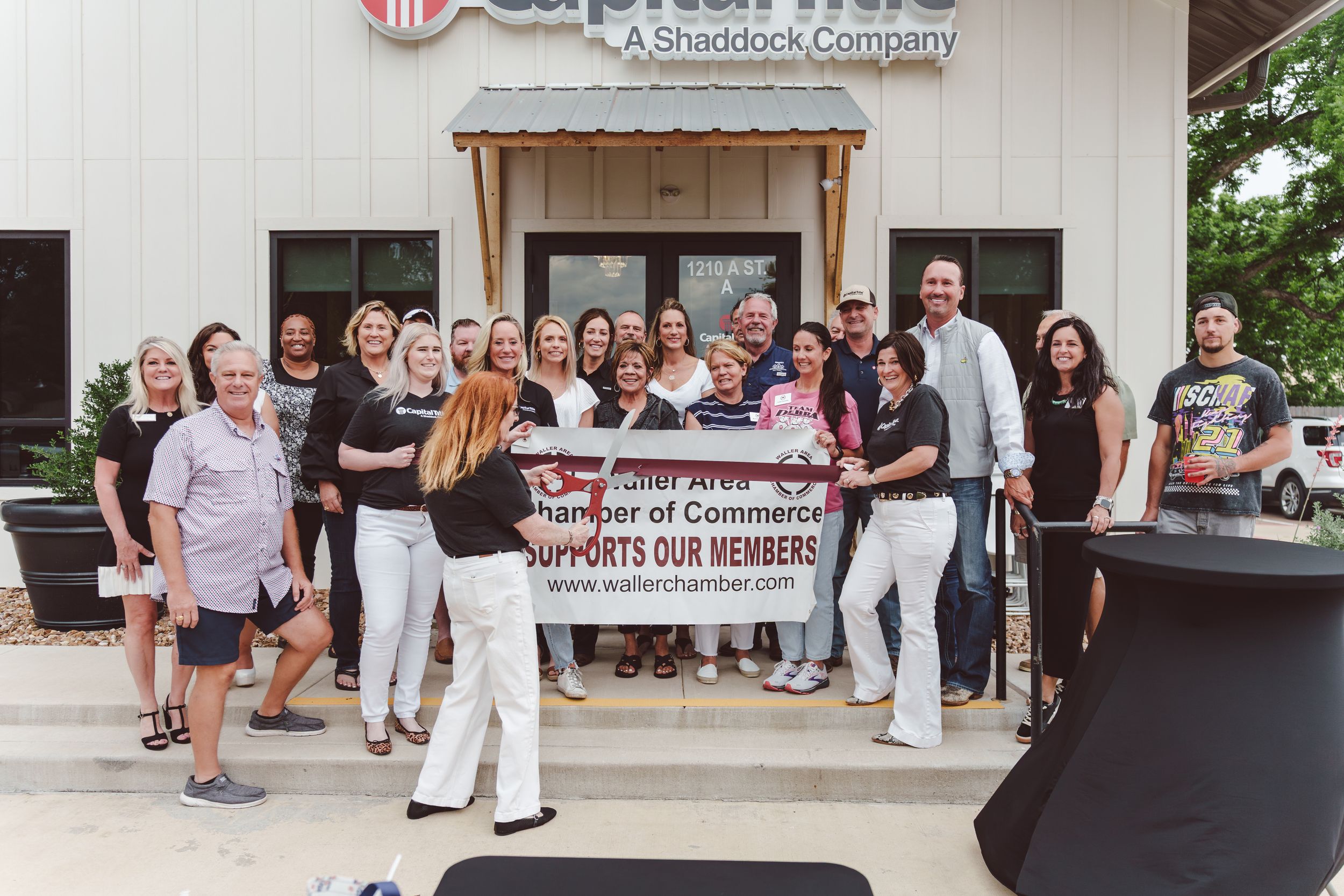 Guests mingle and socialize at an outdoor business networking event with a Chamber of Commerce banner displayed.