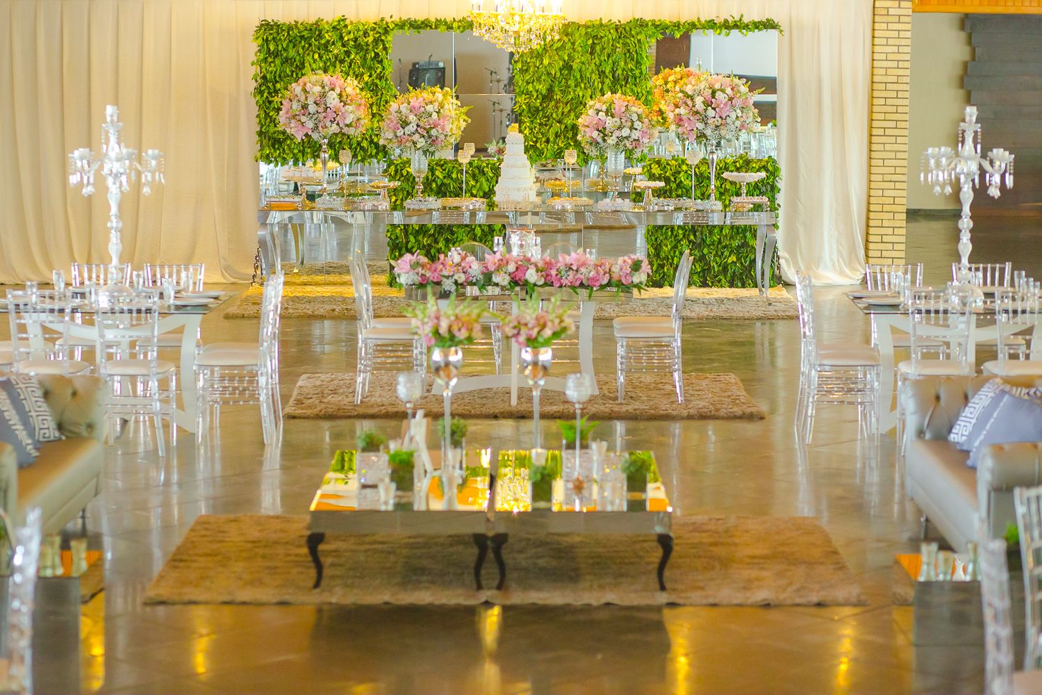 Modern wedding reception setup with mirrored tables, crystal decor and floral centerpieces.