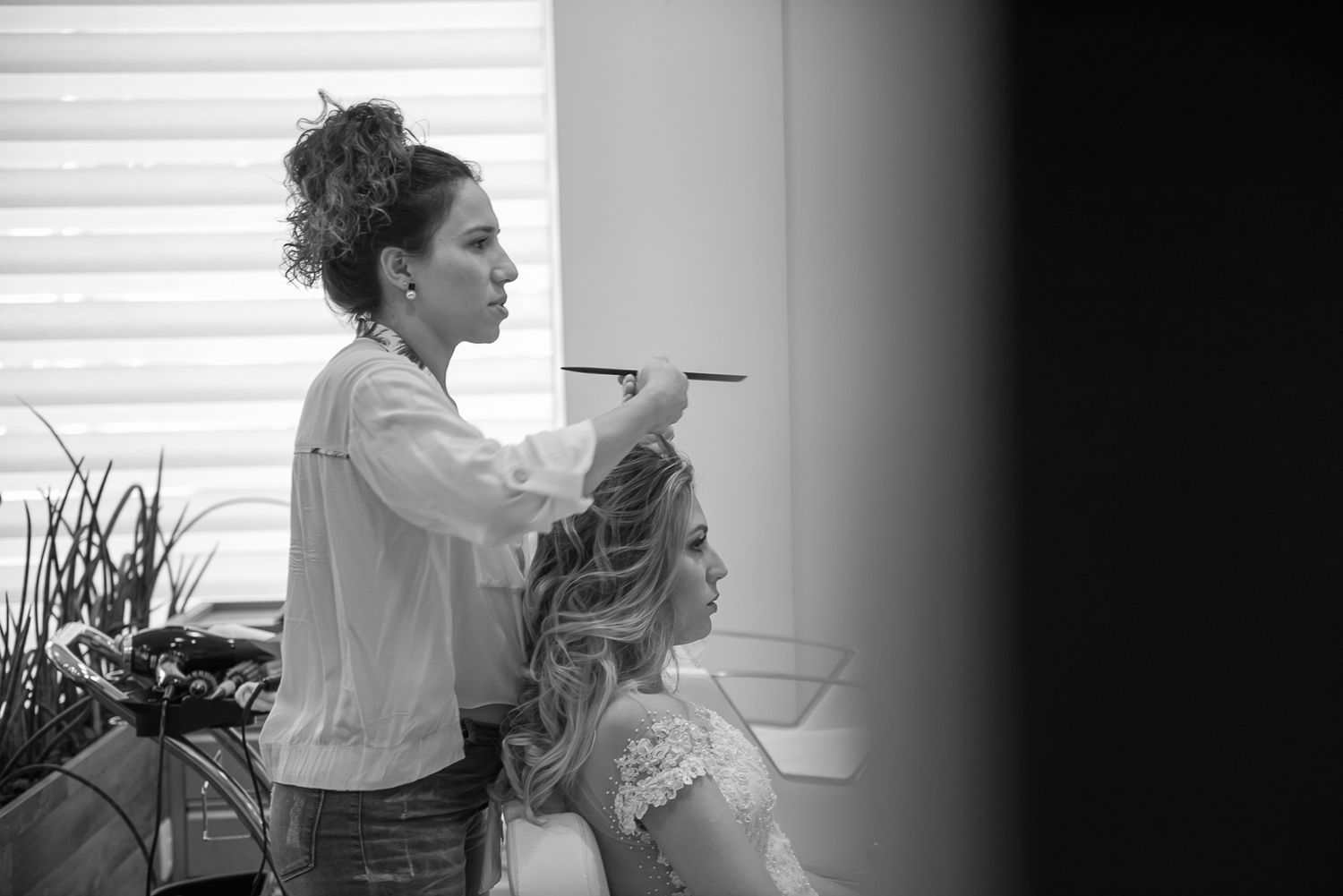 Wedding preparation scene in black and white with styling in progress.