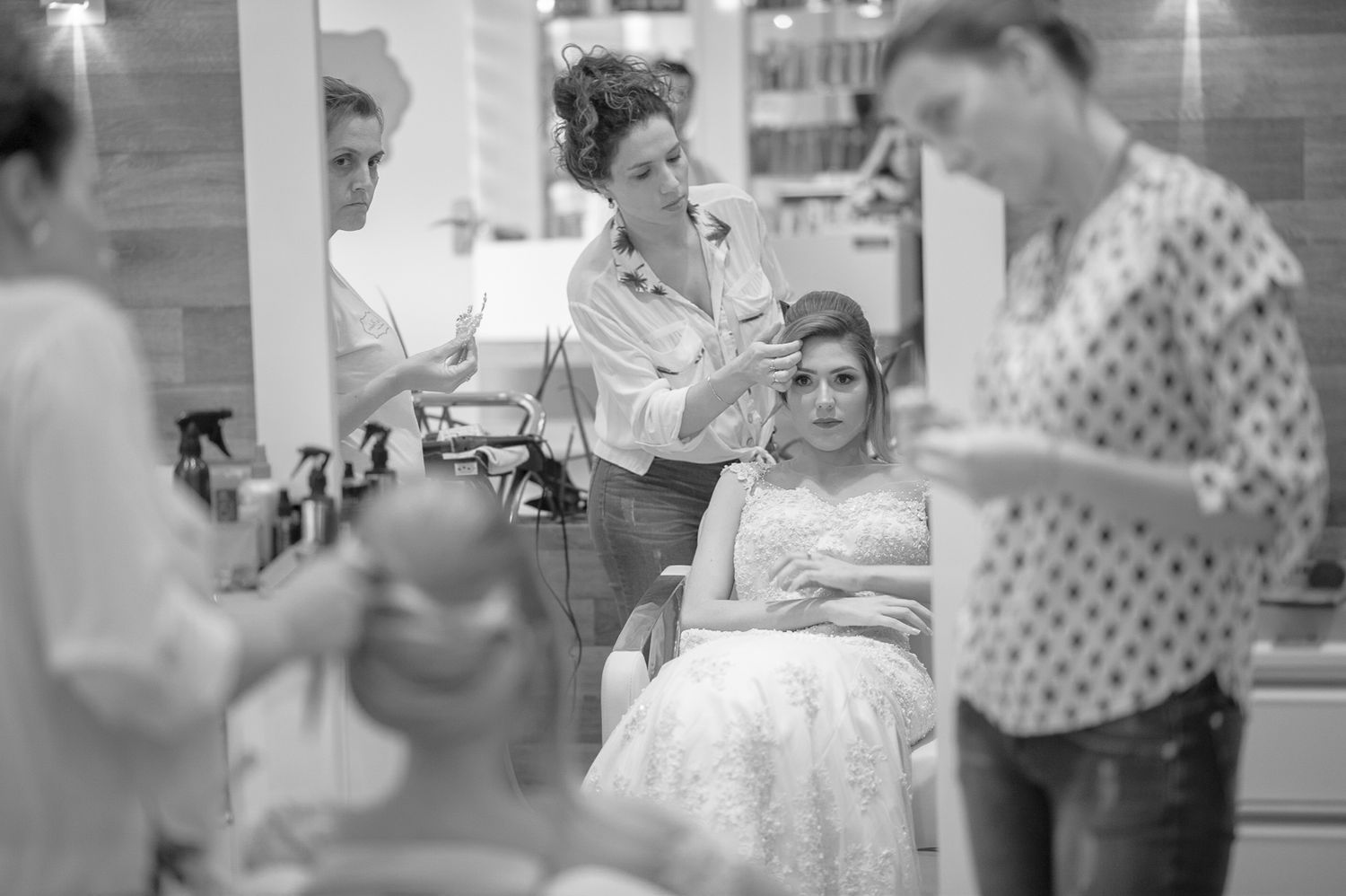 Black and white candid scene of wedding preparation activities.