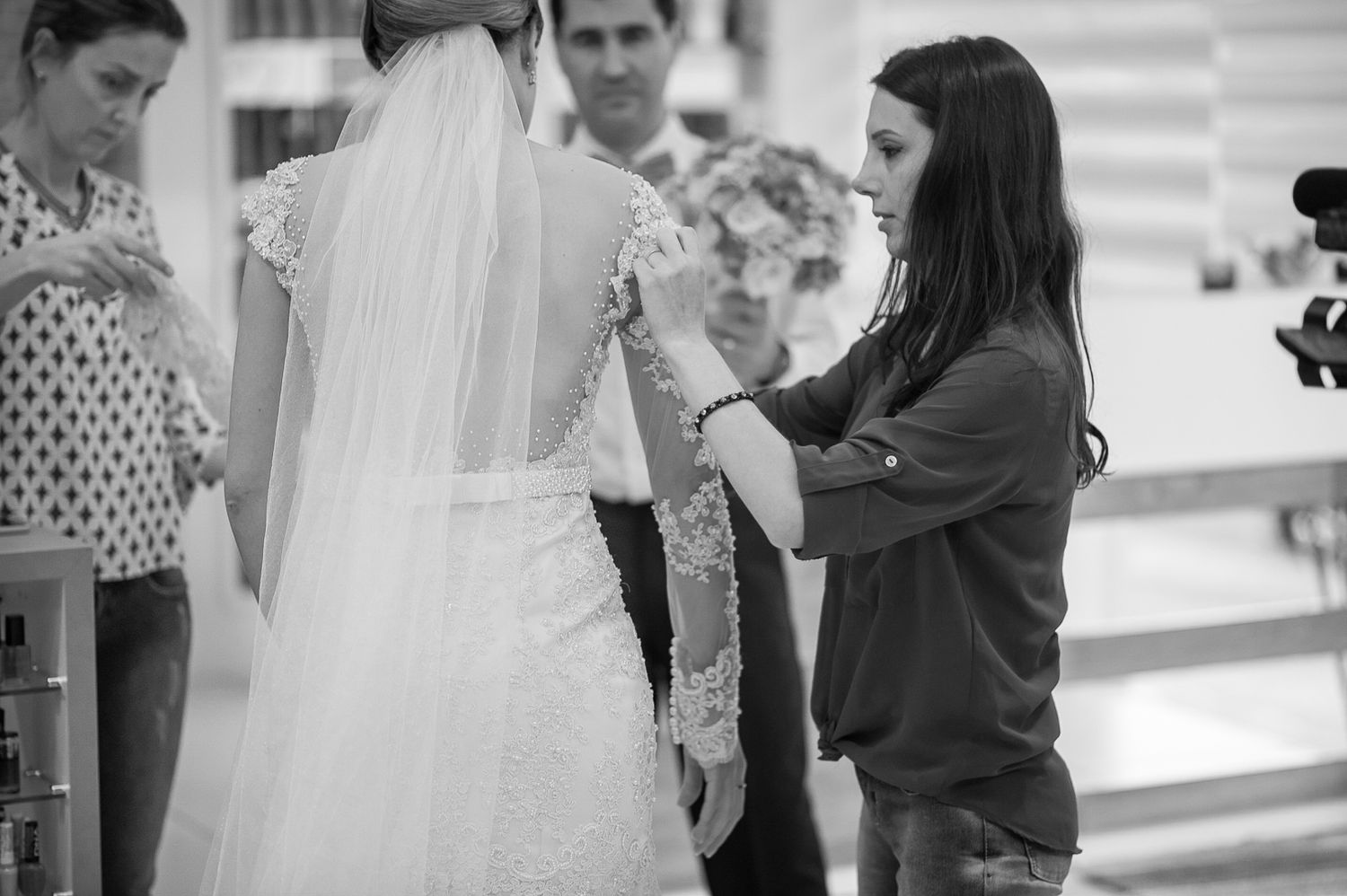 Final adjustments being made to a wedding dress veil and train.