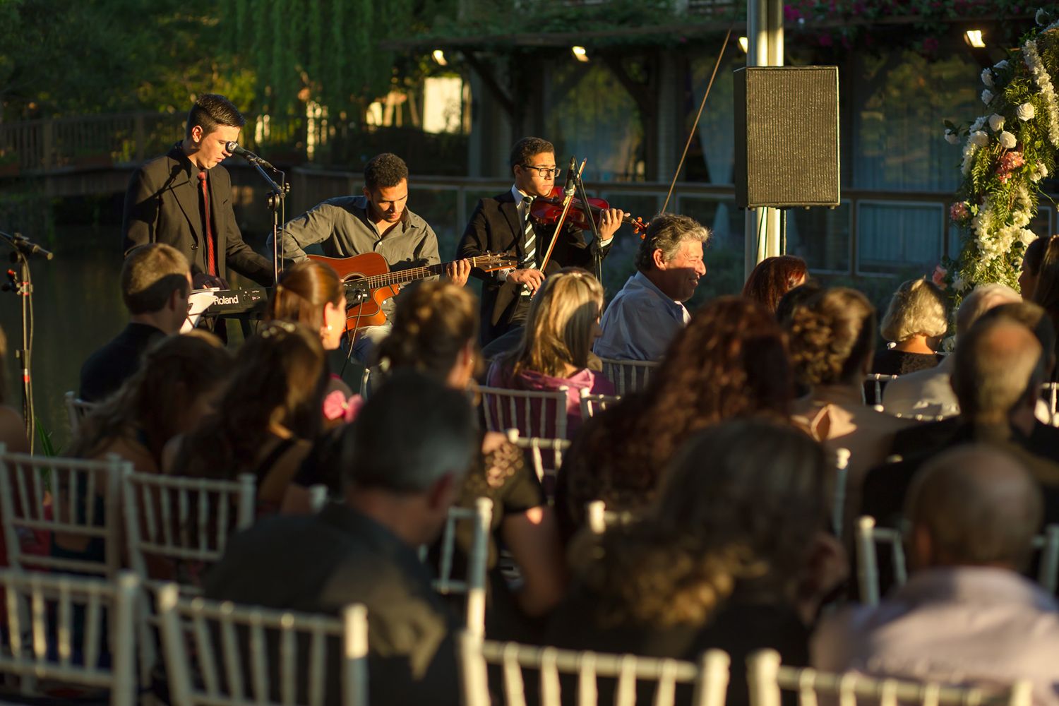 Live band performing at an outdoor evening wedding reception.