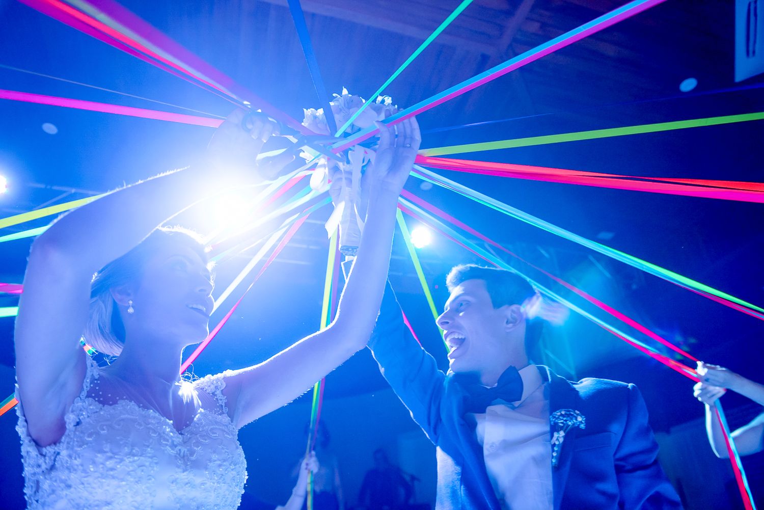 Wedding celebration features colorful laser light show during dance party.