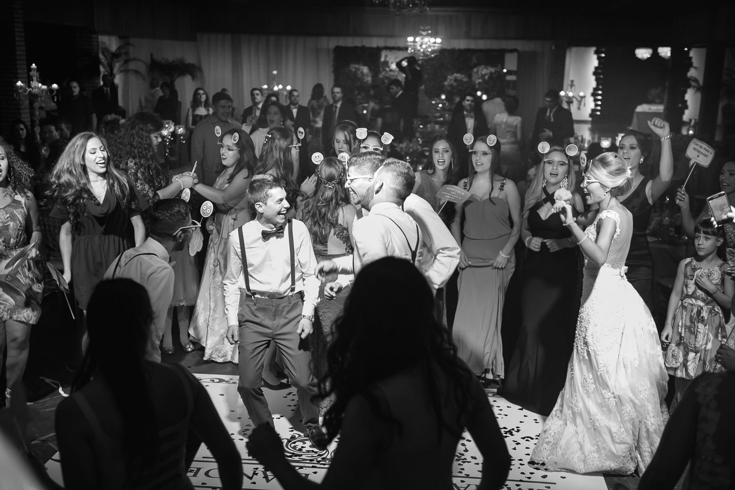 Black and white photo of lively wedding reception dance party.