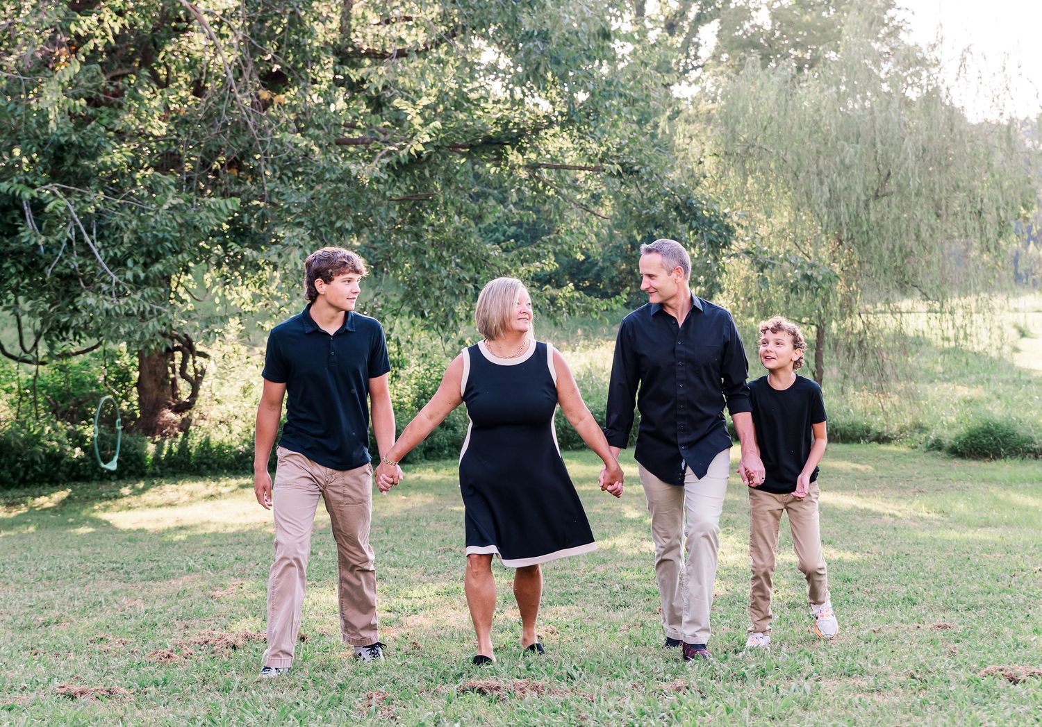 A family of four holding hands, laughing with each other in Kuttawa, Kentucky.