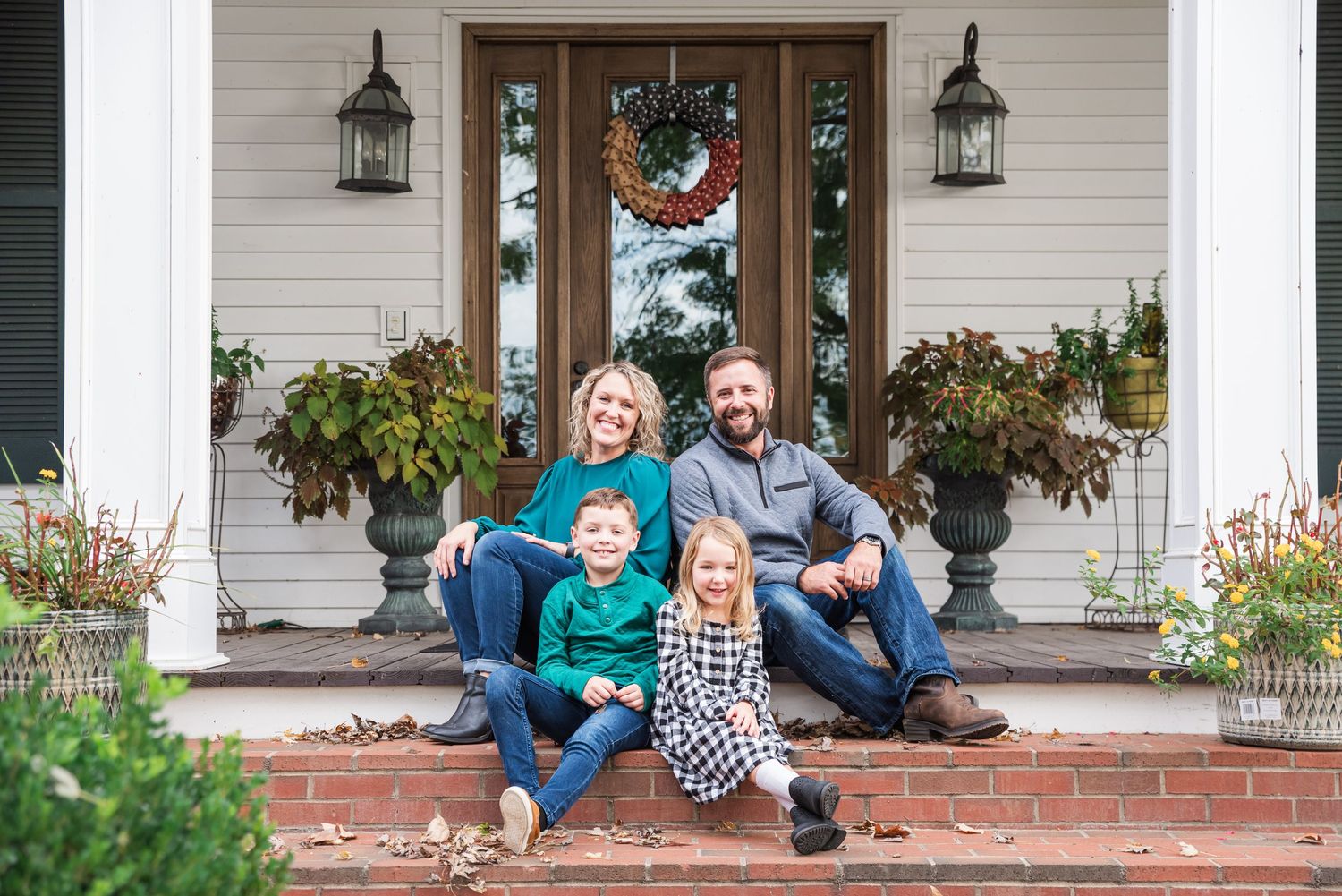 Fall family portraits with parents and 2 children sitting on the steps of a historic house in Eddyville, KY.