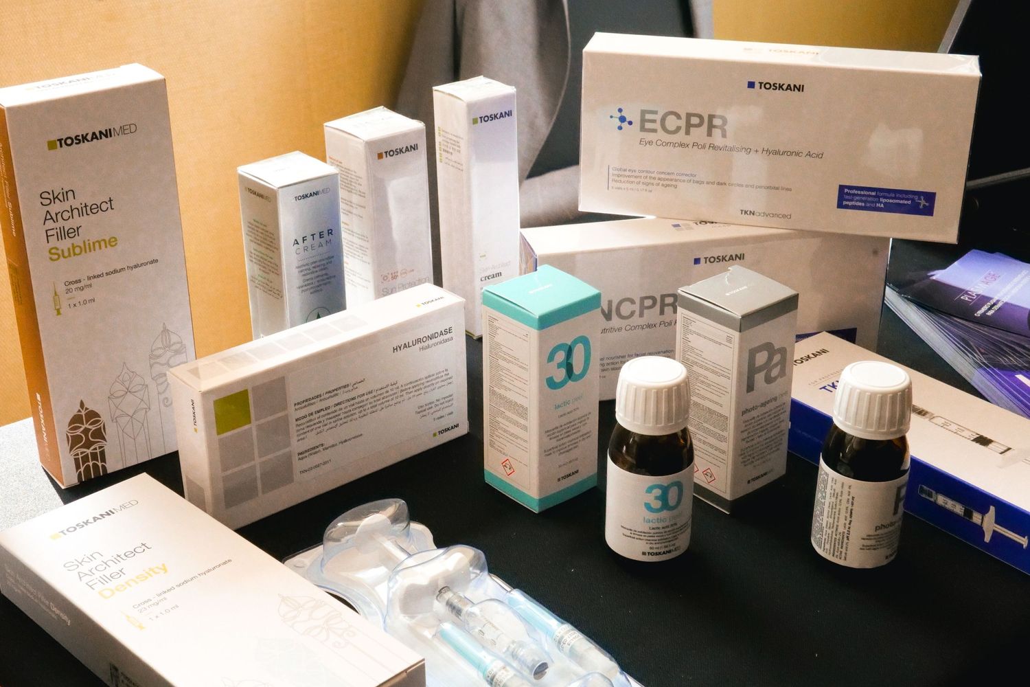 Medical skincare products and ECPR branded boxes displayed on a dark table at a professional conference.