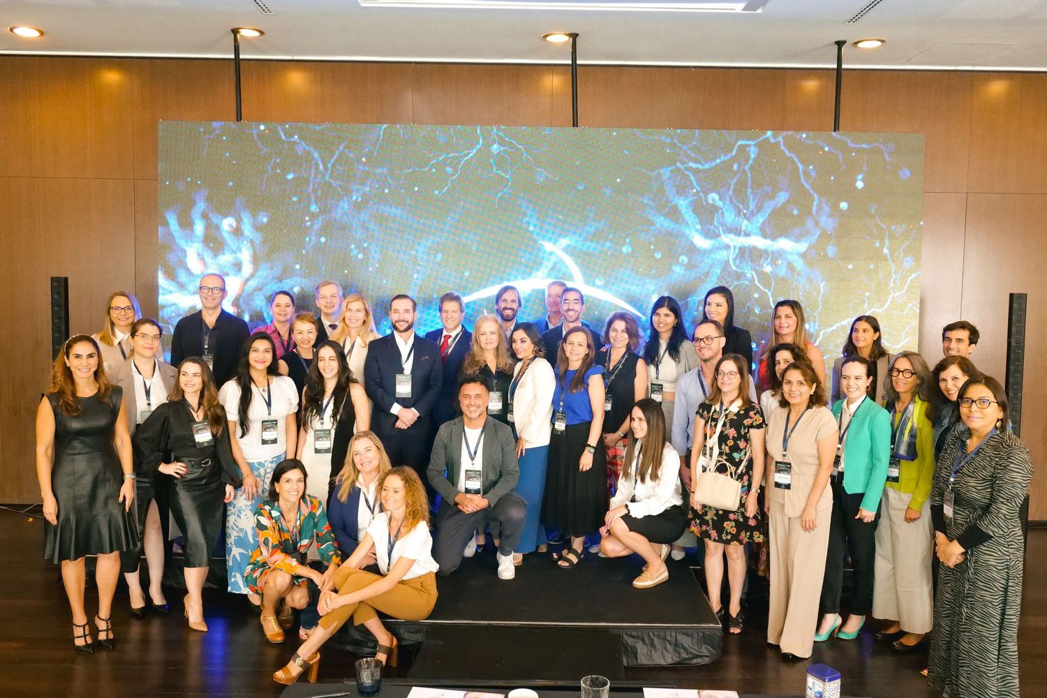 Large group photo of medical conference attendees posing in front of a neuroscience projection screen.