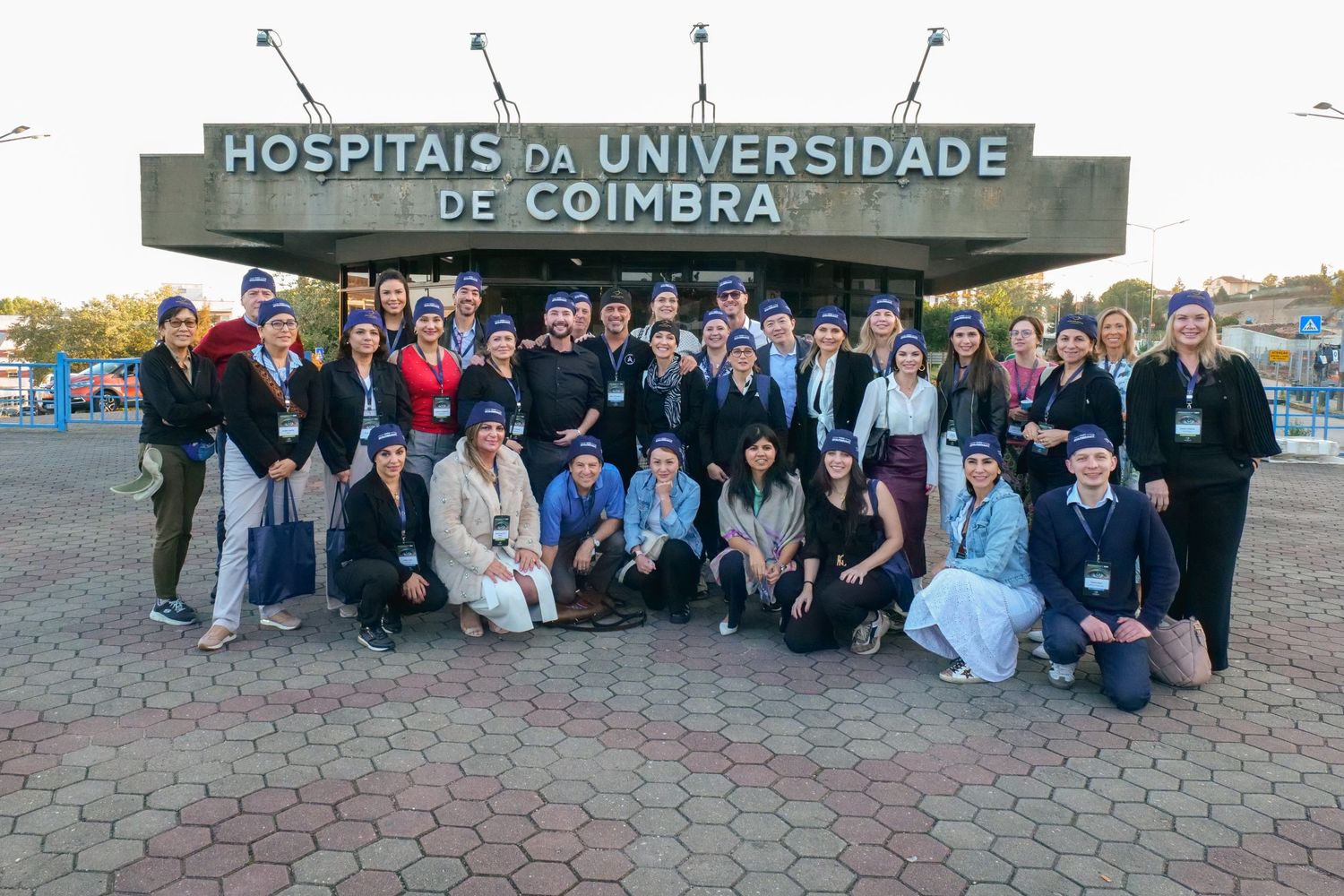 Group of medical students posing outside Hospitais da Universidade de Coimbra in Portugal.