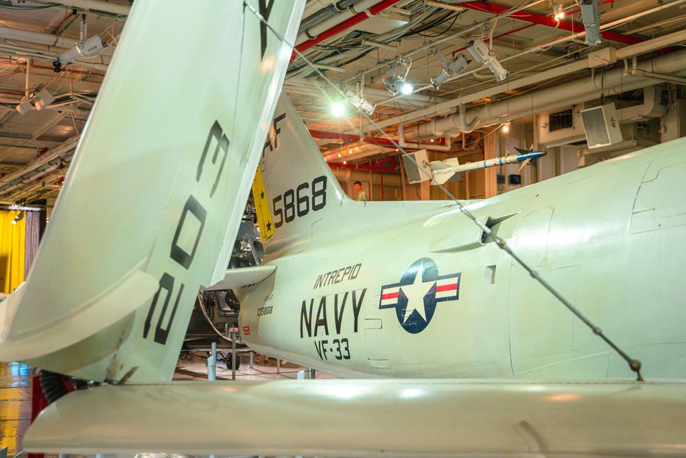 Navy aircraft tail section with identification numbers displayed in museum setting.