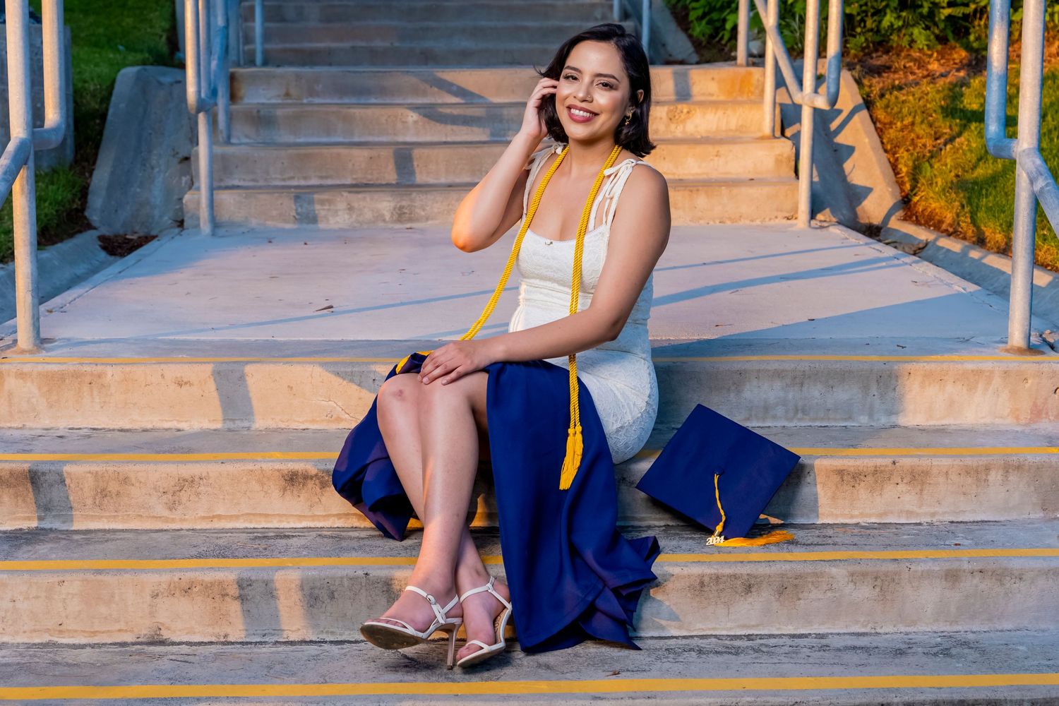 A stylish portrait session on concrete steps featuring a blue and white evening dress ensemble. santa clarita.
