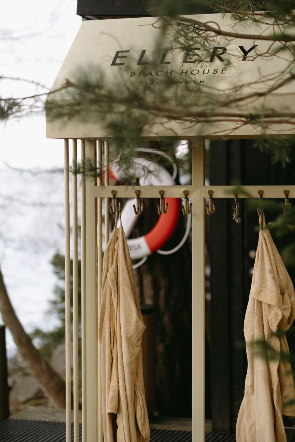 yellow bathrobes hanging in front of outdoor sauna while being captured by lifestyle brand photographer in Stockholm