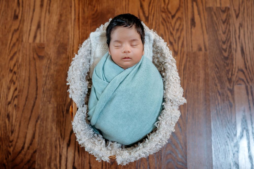 Teal pregnancy progression photo collage with milestone photos laid on wooden floor background.
