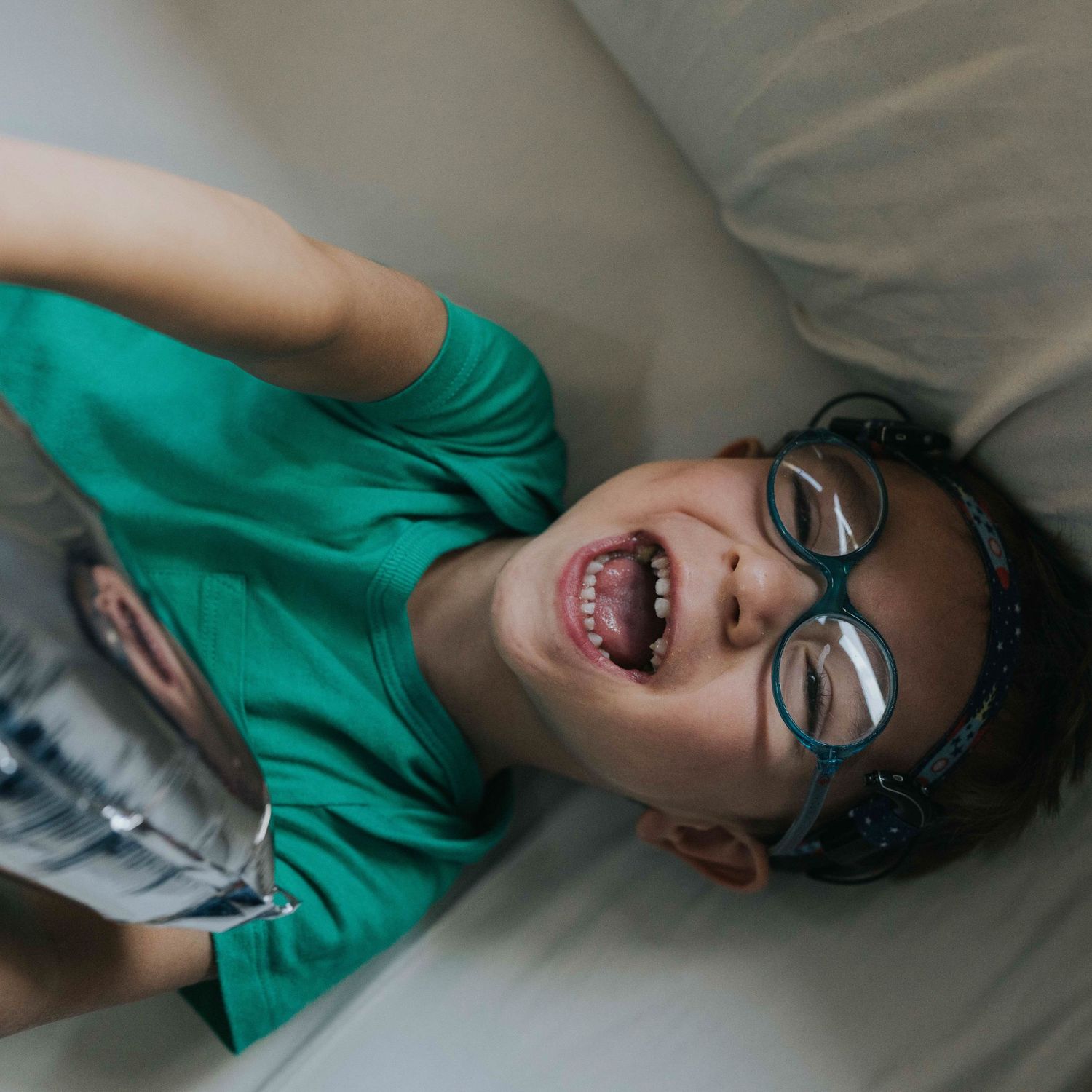 sesión de fotos divertida con niños, niño con gafas riendose