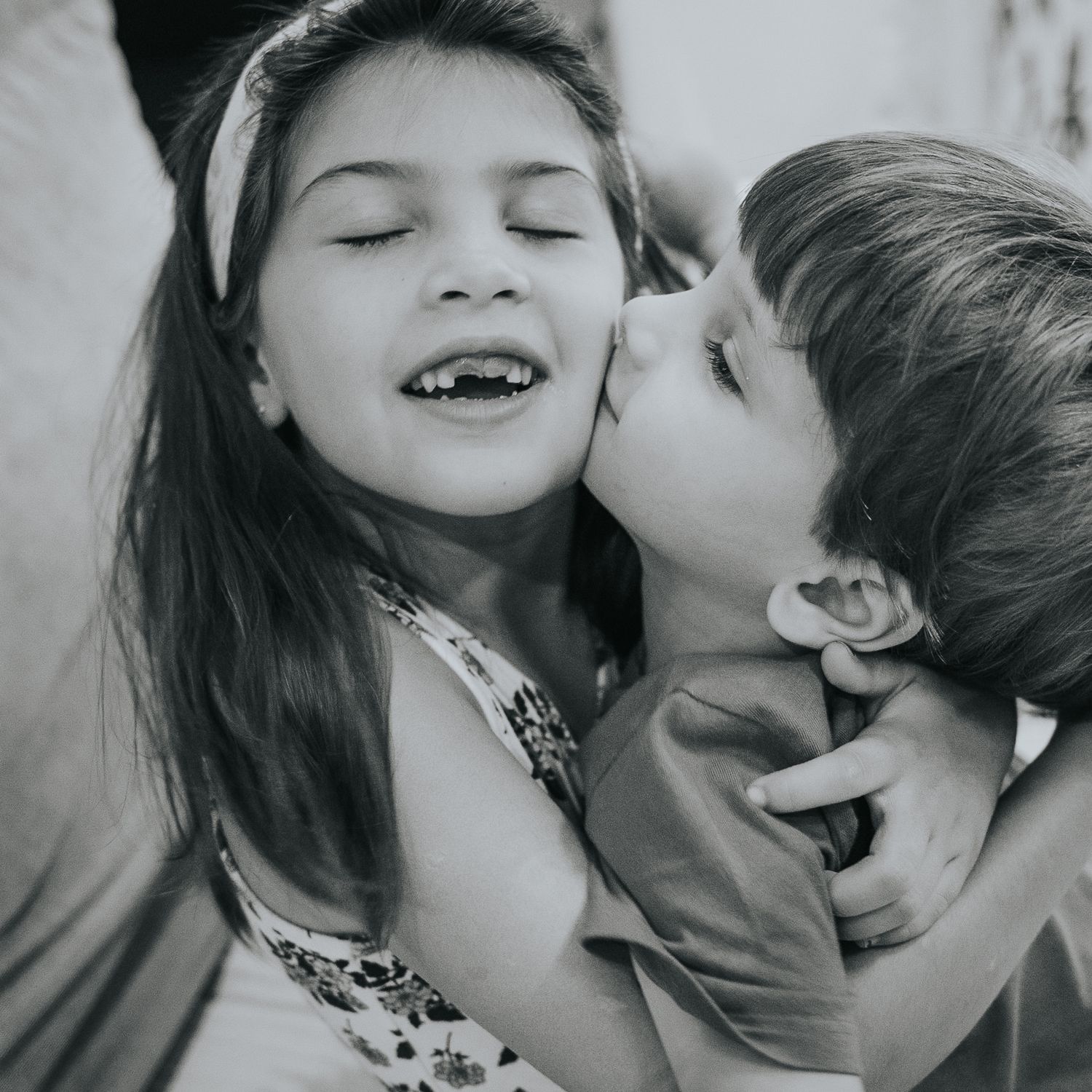 fotografía familiar, dos hermanos dandose un beso en una sesión