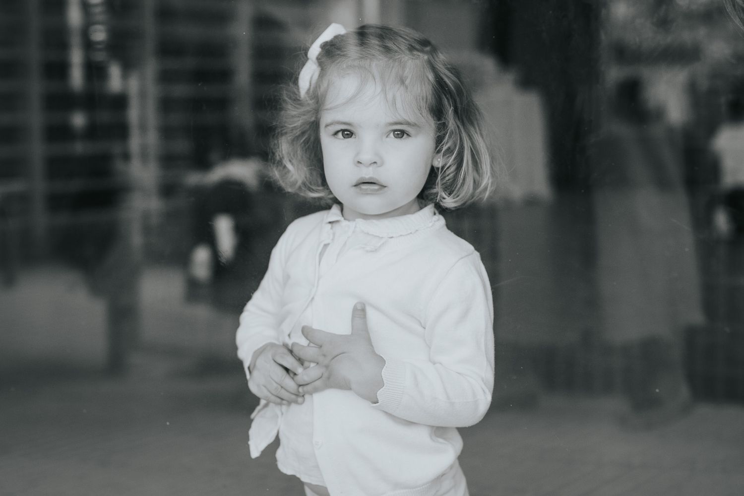 A series of vintage black and white photographs showing a young child in a white dress.