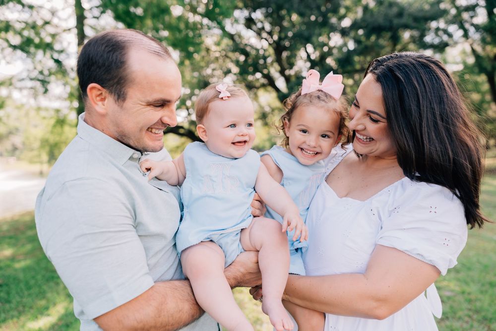 Kids giggling while Mom and Dad hold them in Jesuit Bend Park