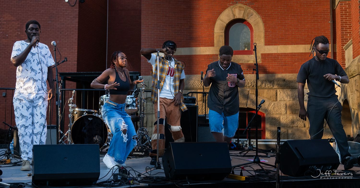Musicians on outdoor stage at music festival.
