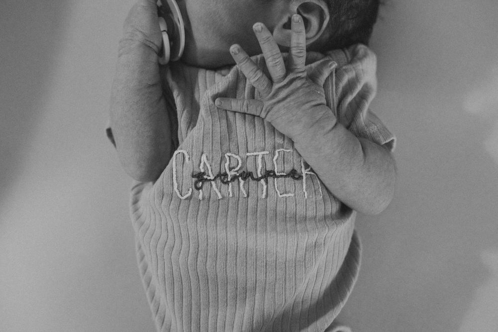 Close-up black and white shot of baby wearing ribbed onesie.