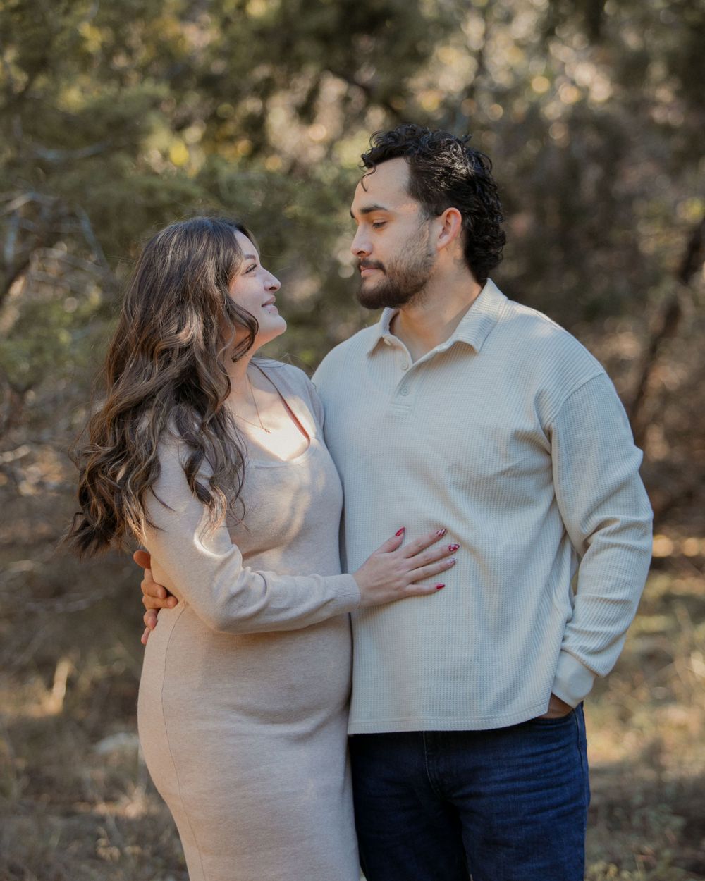 A couple in neutral-toned sweaters shares intimate moments during an outdoor photo session.