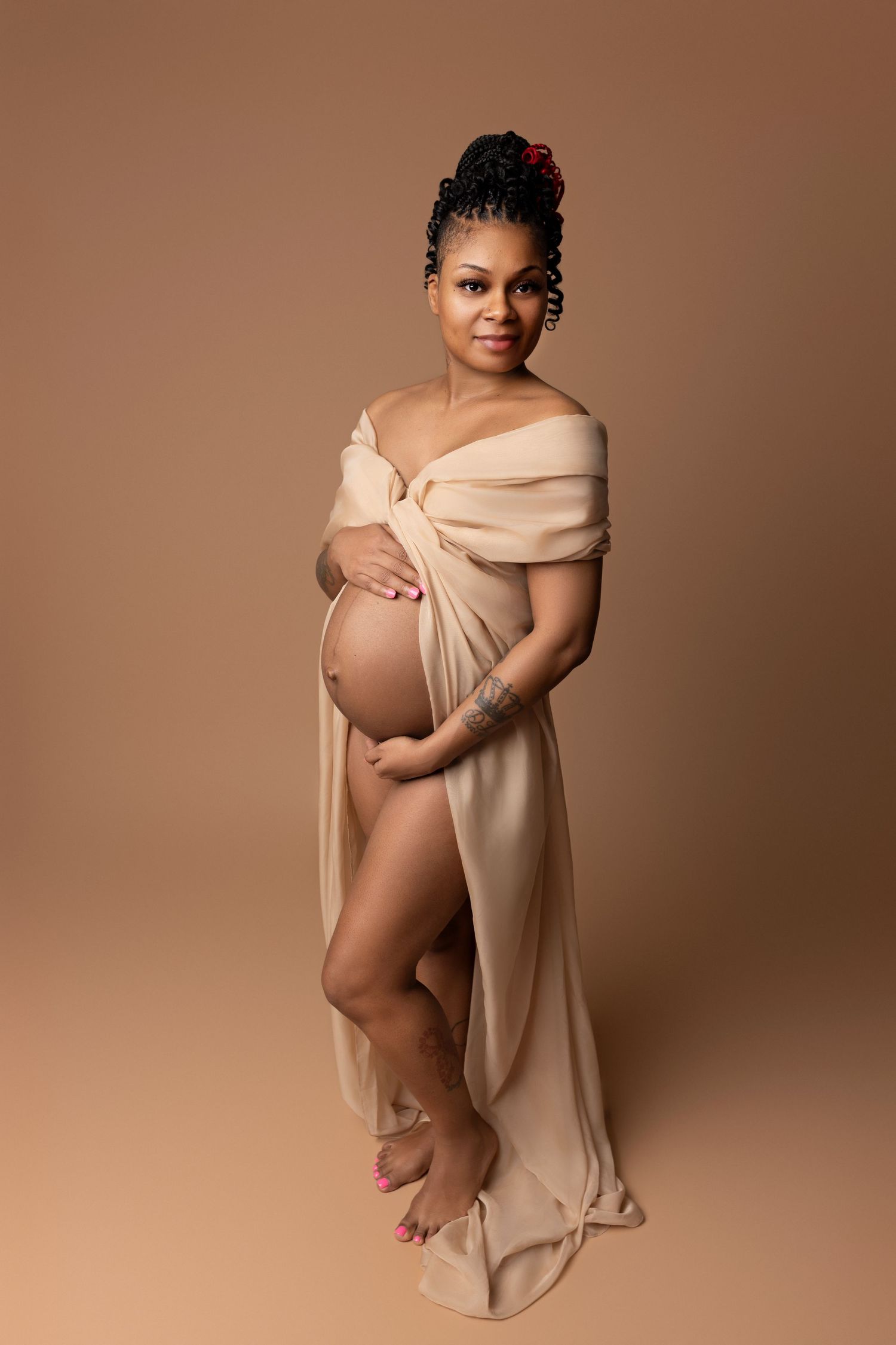 Expecting mother in a sheer champagne fabric dress, elegantly posed at our studio near Georgetown, TX