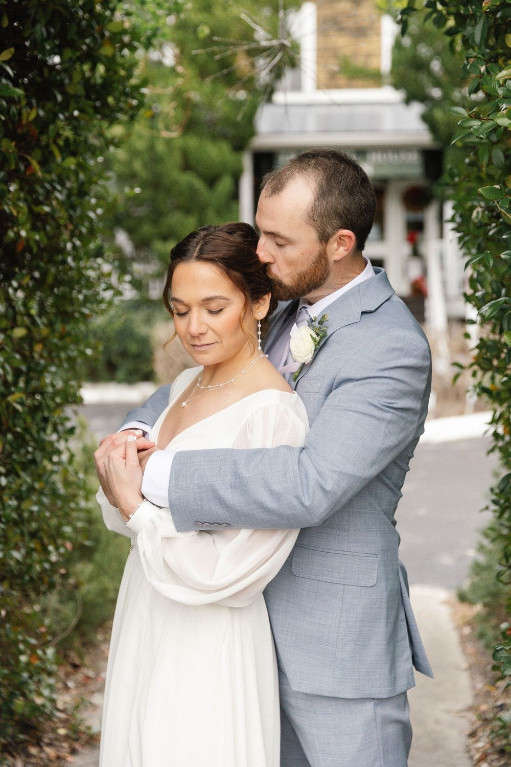 Intimate wedding photos captured in a garden setting with lush greenery.