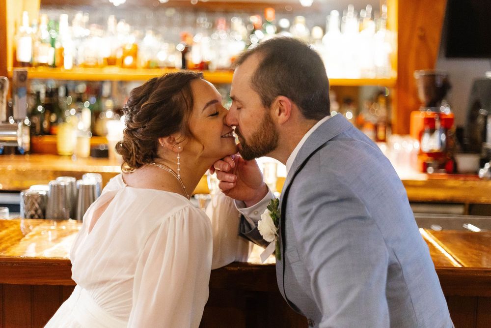 Romantic couple sharing intimate moments at a warmly lit bar counter.