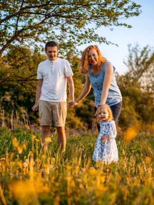 A family enjoys a golden sunset moment in a wildflower meadow during summer.
