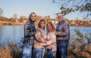 A series of outdoor family portraits taken at sunset by a lake with golden autumn colors in the background.