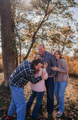A playful series of photos showing family members interacting outdoors among autumn trees and fallen leaves.