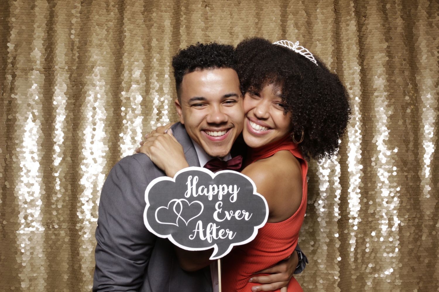 a man and woman hugging in a photobooth at a wedding