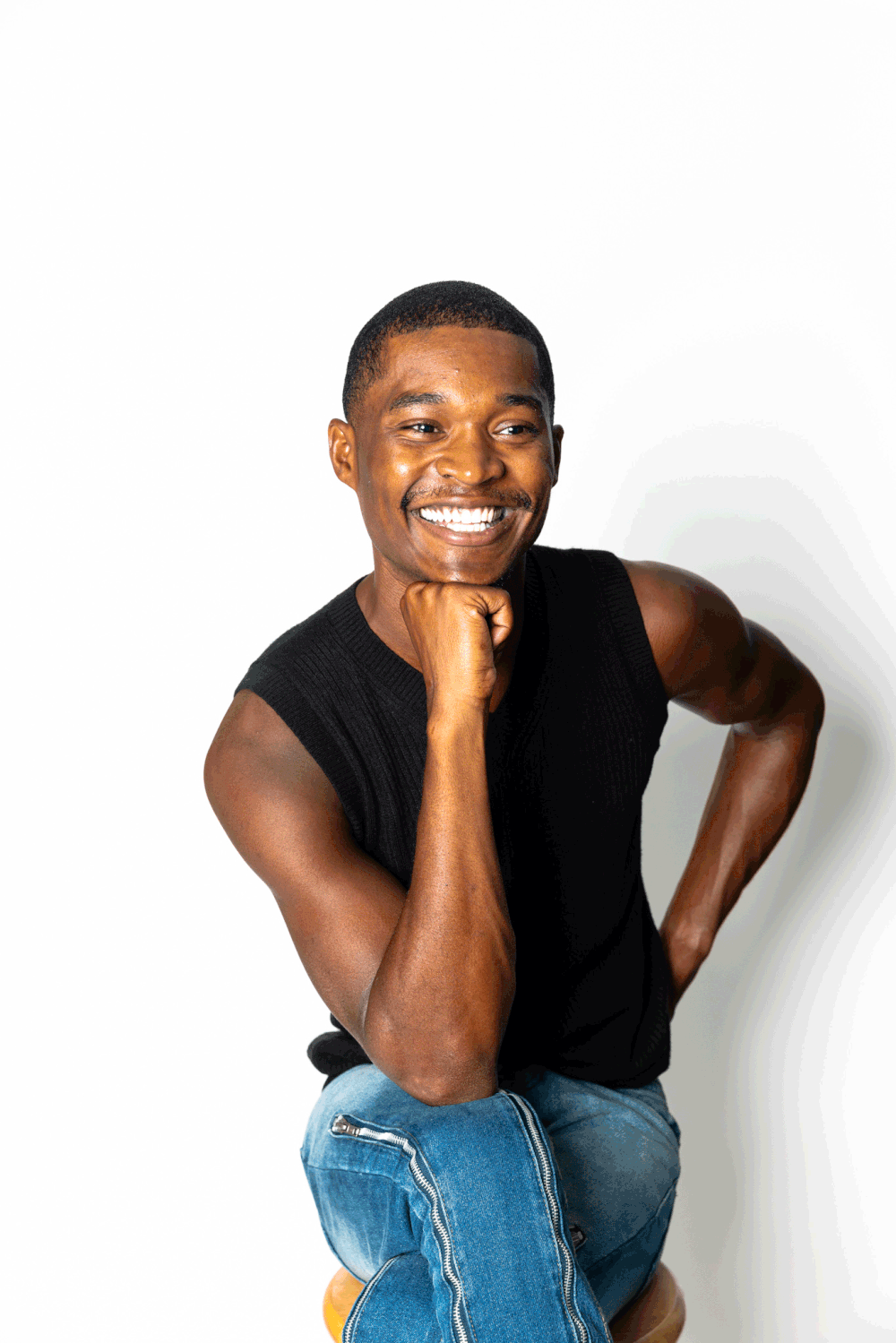 Model smiling on stool at a studio in Phoenix
