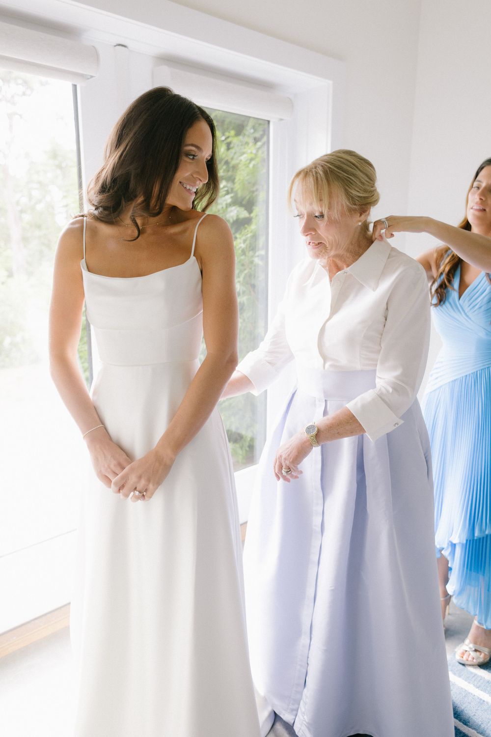 Wedding dress fitting scene with people in white and blue dresses.