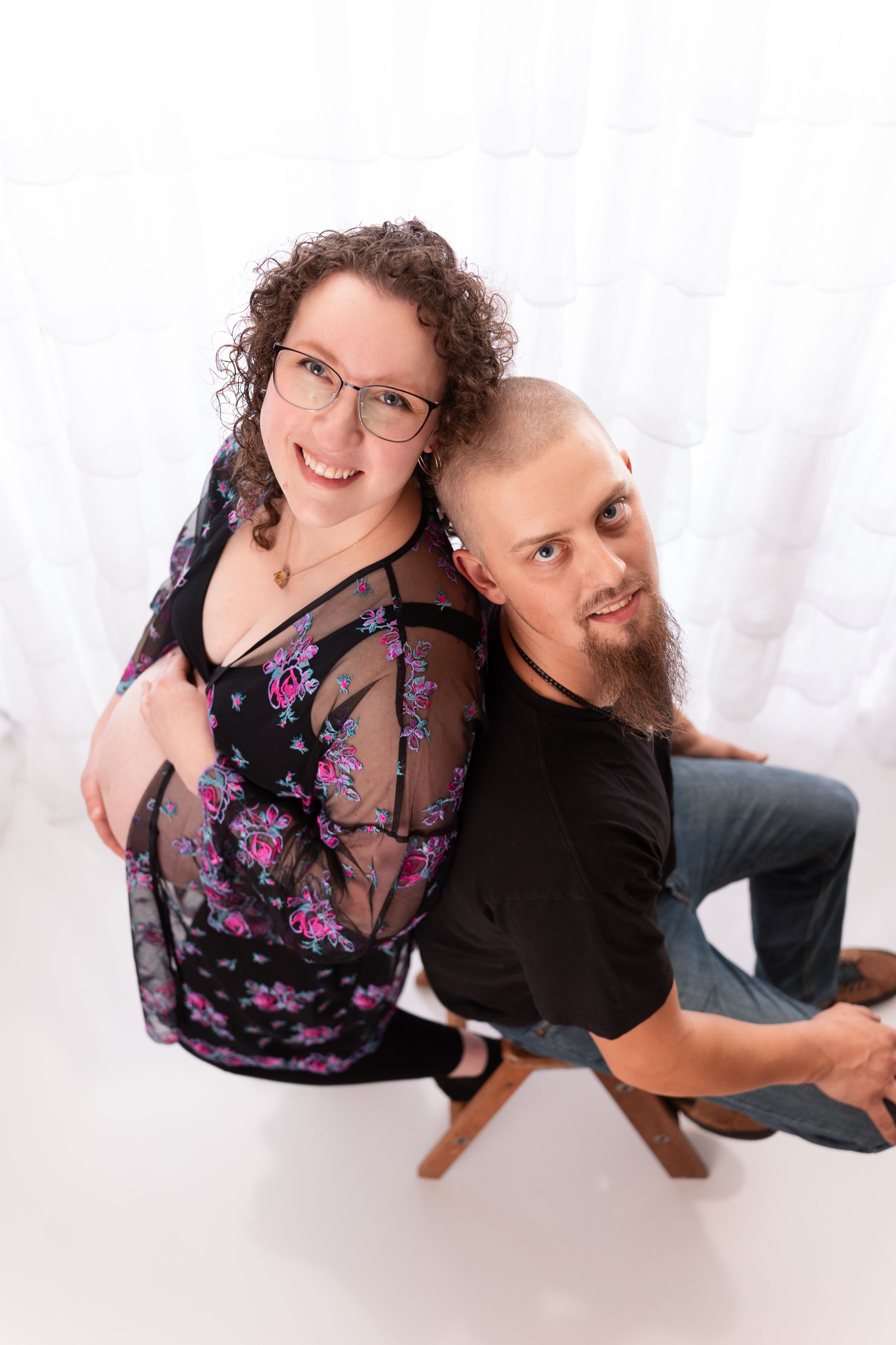 Overhead view of couple posing together during maternity photoshoot.