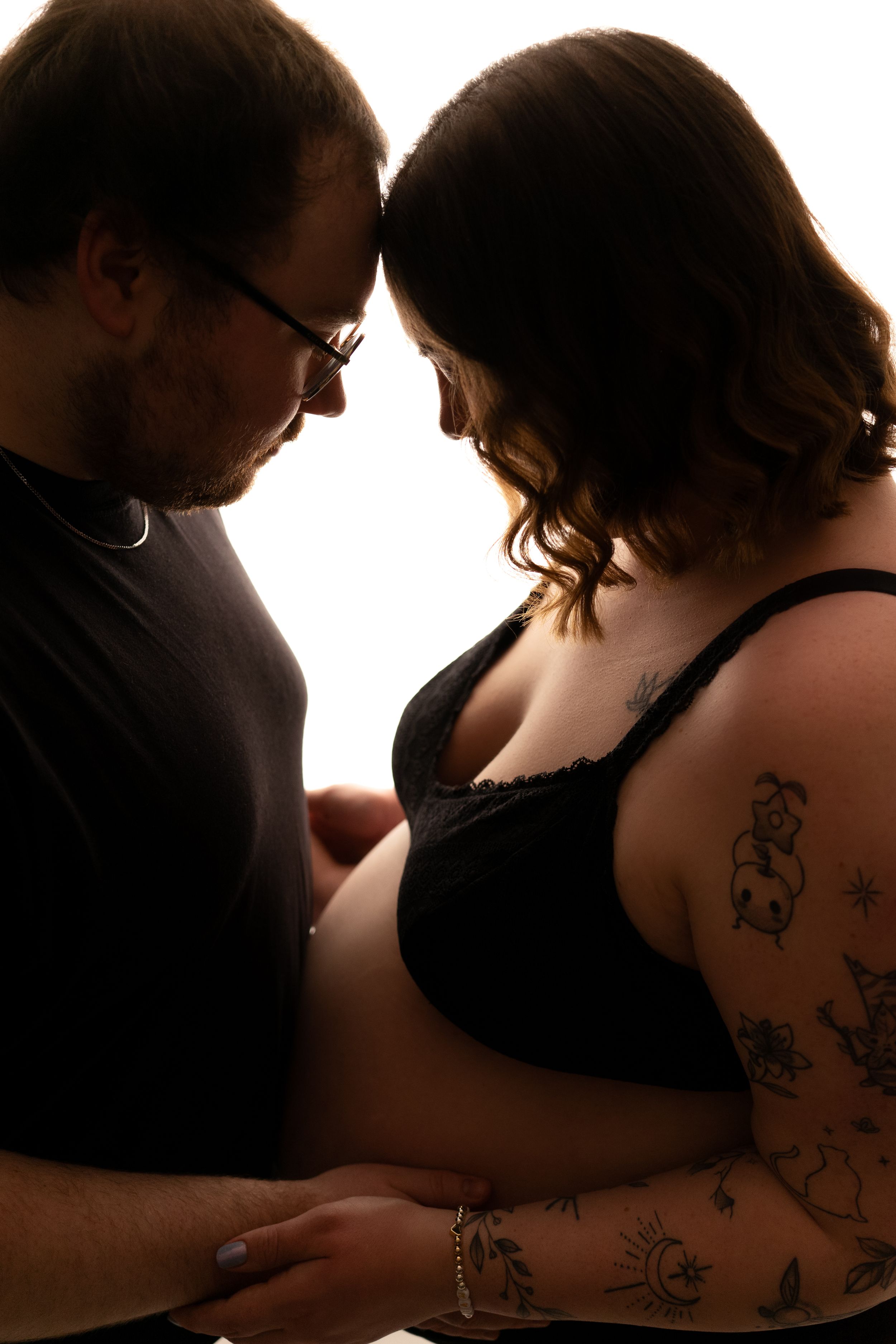 Silhouetted maternity photos showing intimate moments between expectant parents. Maternity photography session in Enumclaw, Washington by Ma