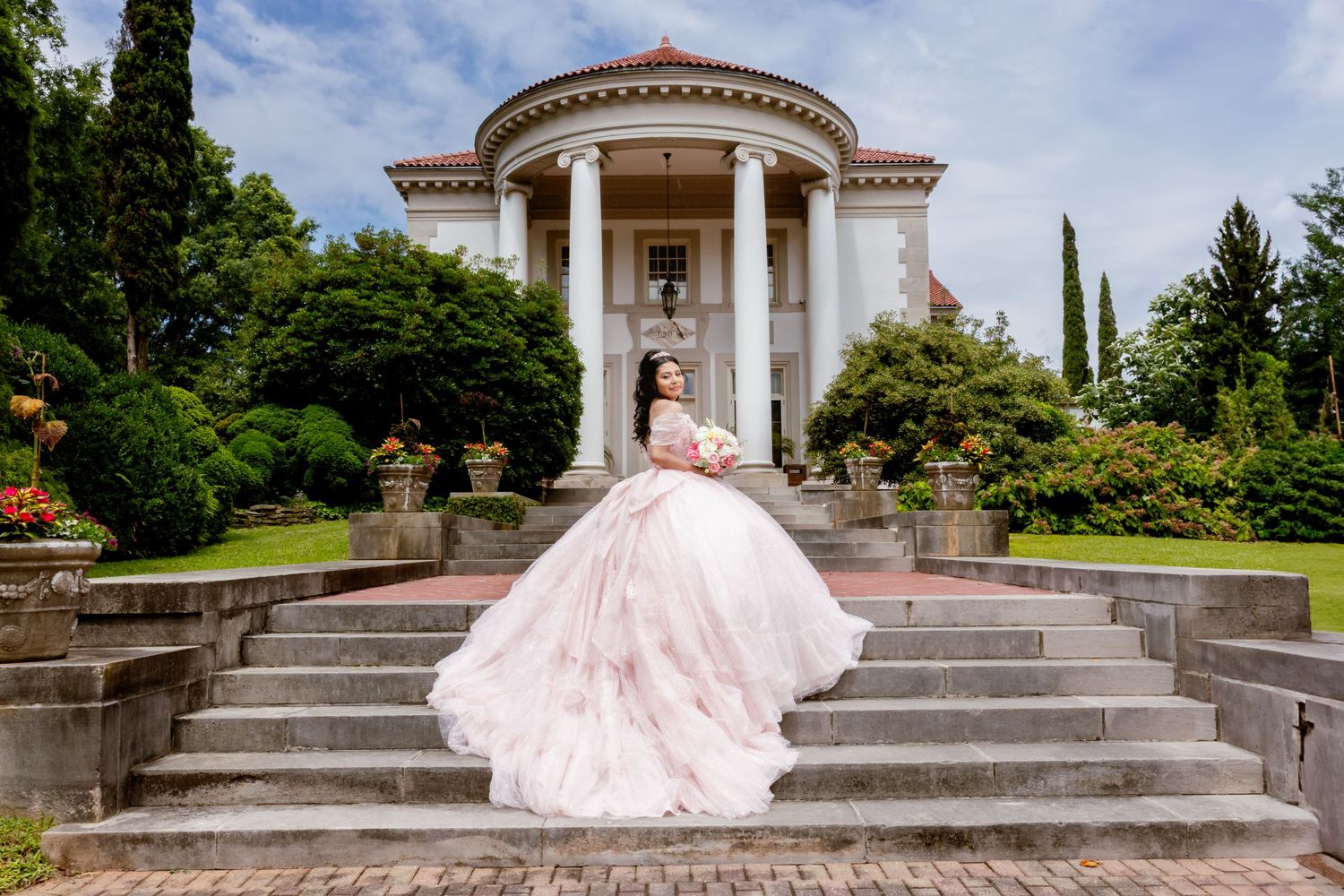 Pink ballgown dress photographed at classical columned building with grand steps.