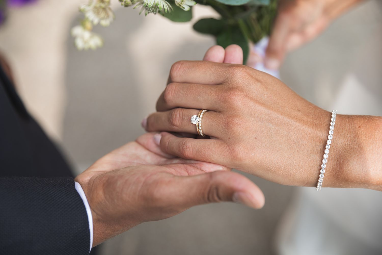 Close-up shots of hands exchanging wedding rings during a marriage ceremony.