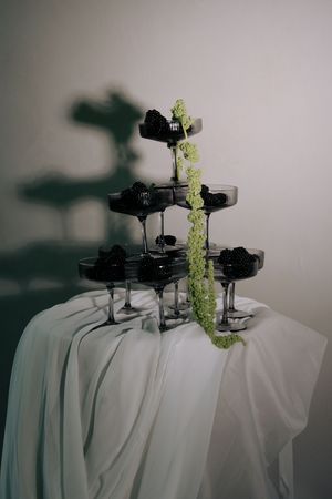 A sequence of black headphones with delicate green flowers growing from them against a white background.