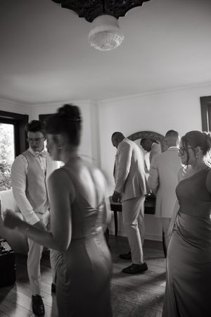 Black and white photo series showing wedding guests mingling and dancing at a reception in formal attire.
