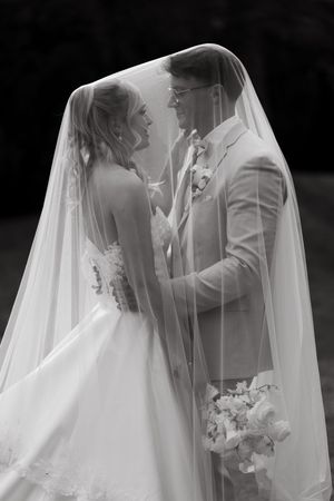 Romantic black and white wedding photos showing intimate moments between newlyweds with a flowing veil.