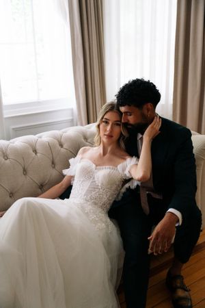 Intimate moment between couple on tufted sofa in elegant room.