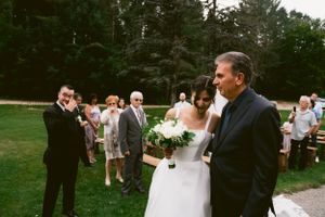 Outdoor wedding ceremony with guests gathered on a garden path.