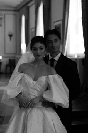 A romantic black and white wedding portrait featuring a bride in a dramatic puff-sleeve gown.