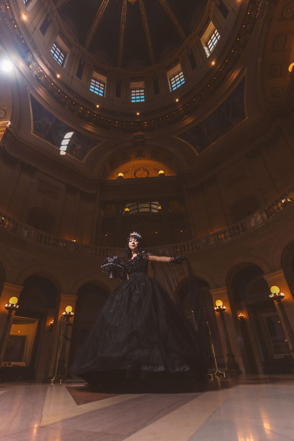 Grand architectural interior of a historic building with ornate domed ceiling and dramatic lighting.