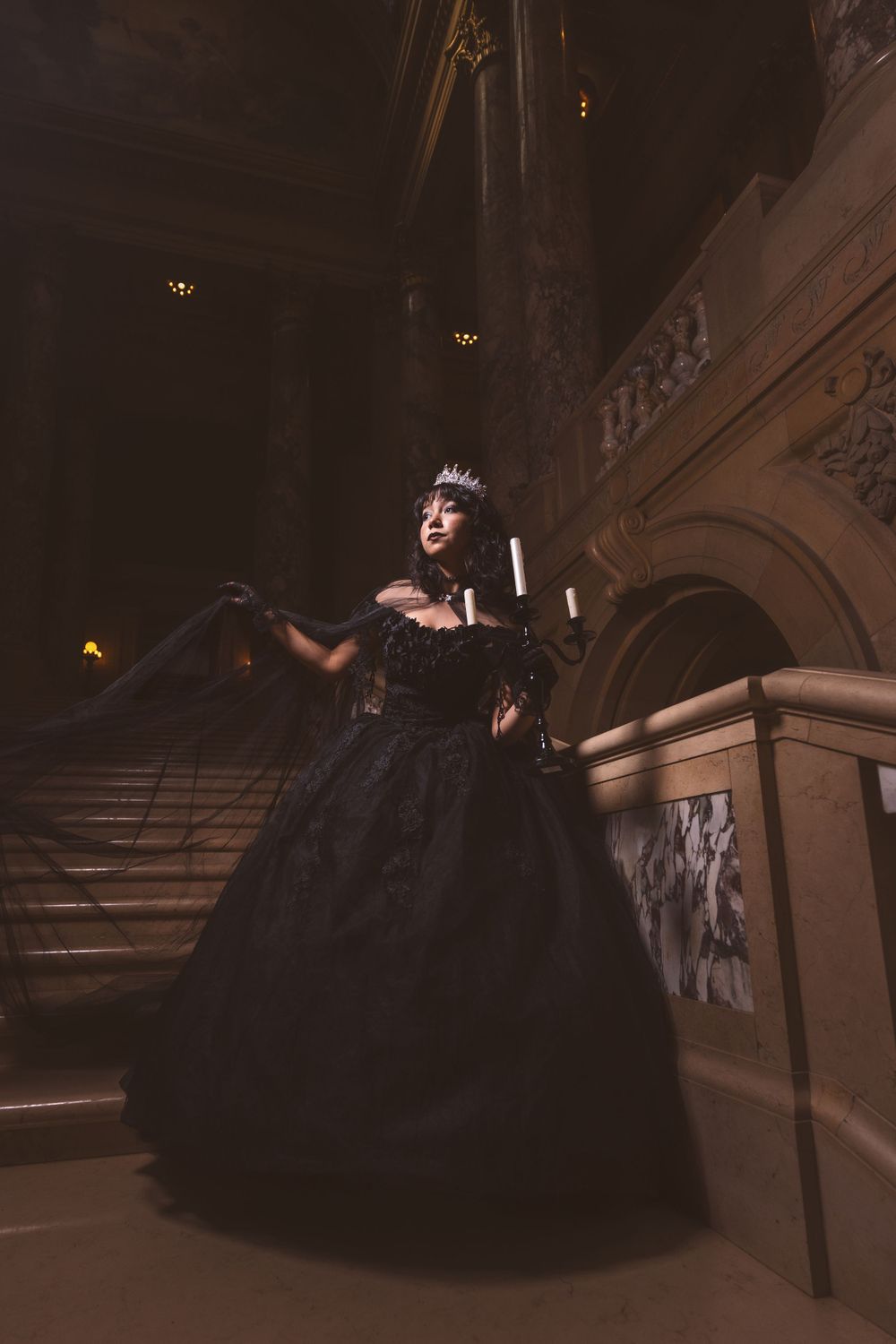 A flowing black ball gown captured in a series of poses on a grand staircase.