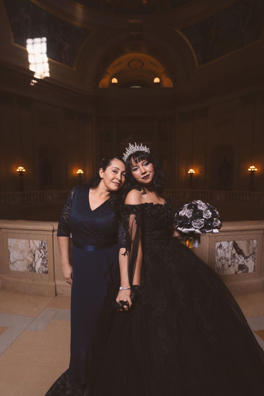 Formal gathering in an ornate venue with dramatic architectural details and warm lighting.