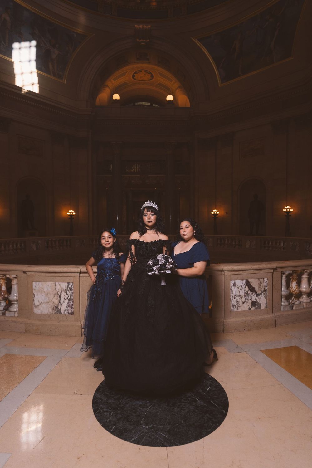 Dramatic photoshoot in an elegant ballroom with ornate architecture and marble floors.