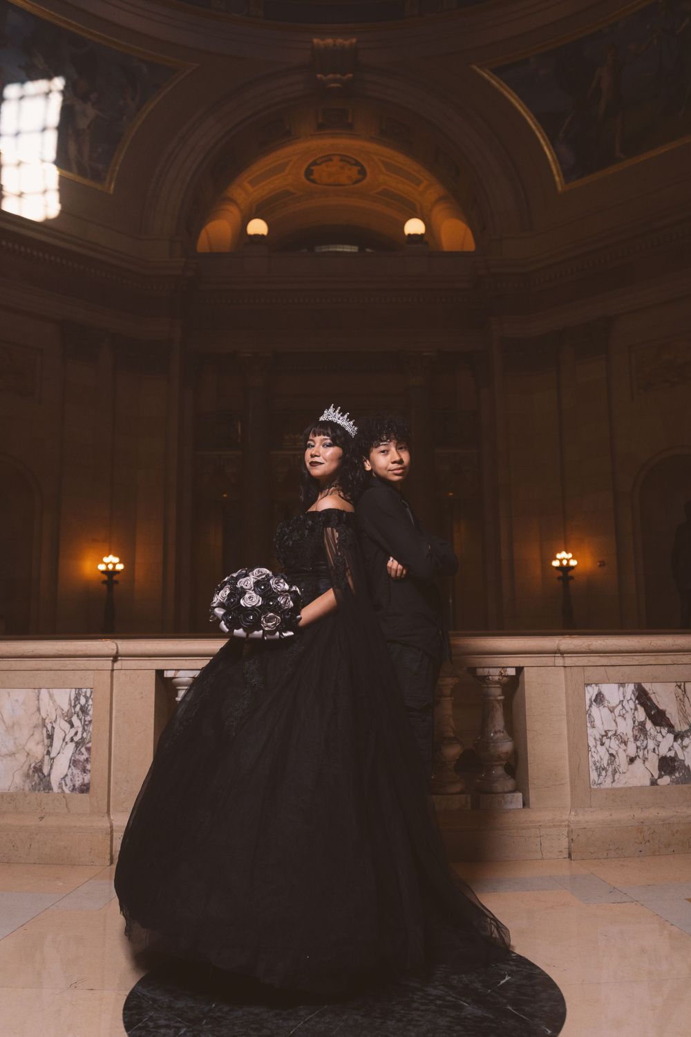 Elegant formal photoshoot in a historic venue with marble floors and classical architecture.